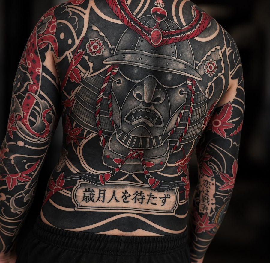 Rückenstück mit Samurai-Maske, Ahornblättern und Schriftzug in Schwarz und Rot – Tattoo aus Bad Bramstedt